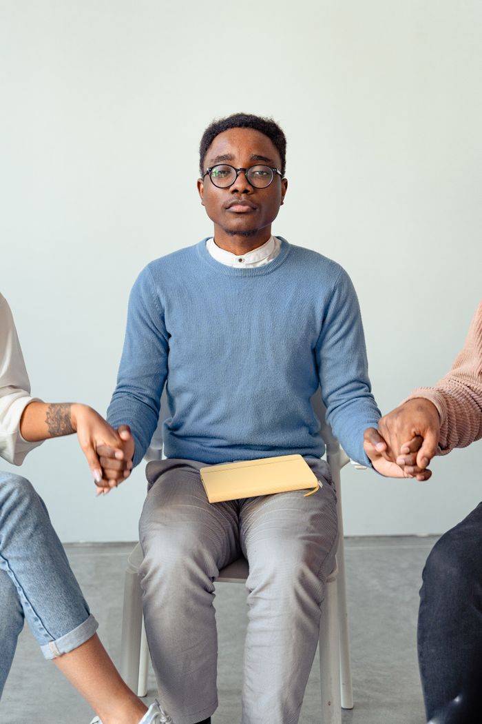 about-us-02 A therapist conducting a supportive group therapy session, indoors, focusing on mental health.