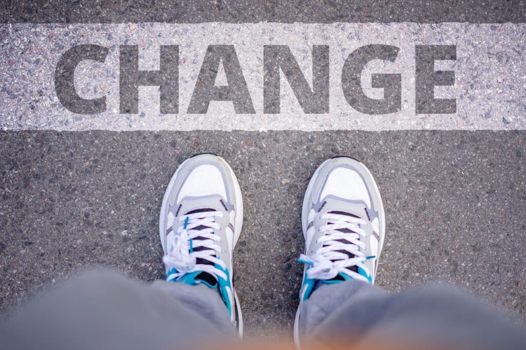 Information and Resources Close-up of sneakers on street with 'Change' text, symbolizing transformation.