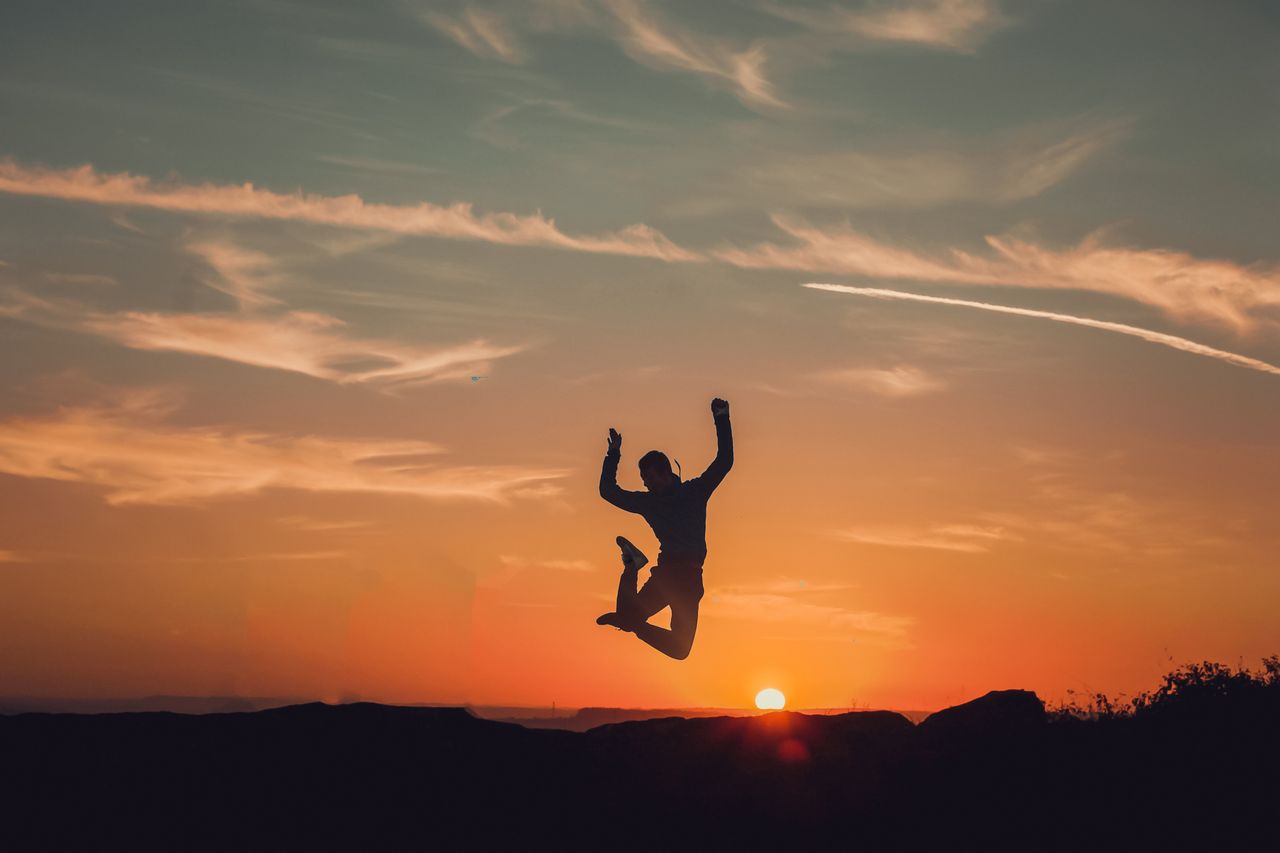 Mastering the First Impression: Your intriguing post title goes here A person silhouetted against a stunning sunset, capturing a moment of freedom and joy.