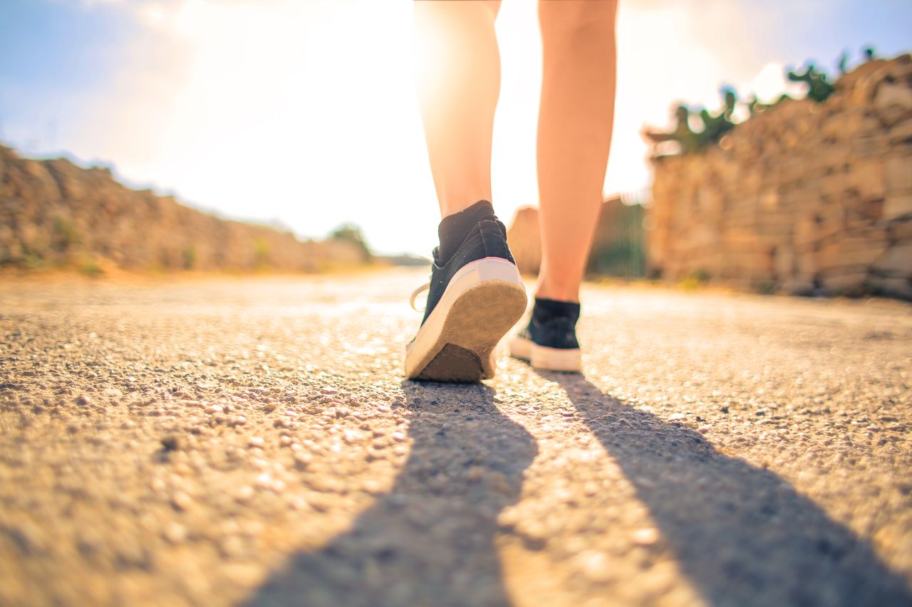 The Art of Drawing Readers In: Your attractive post title goes here A woman walks down a sunlit path in summer, highlighting leisure and travel outdoors.